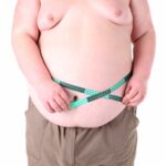 Fat man holding measuring tape. Conceptual photo of weight loss. Isolated on white